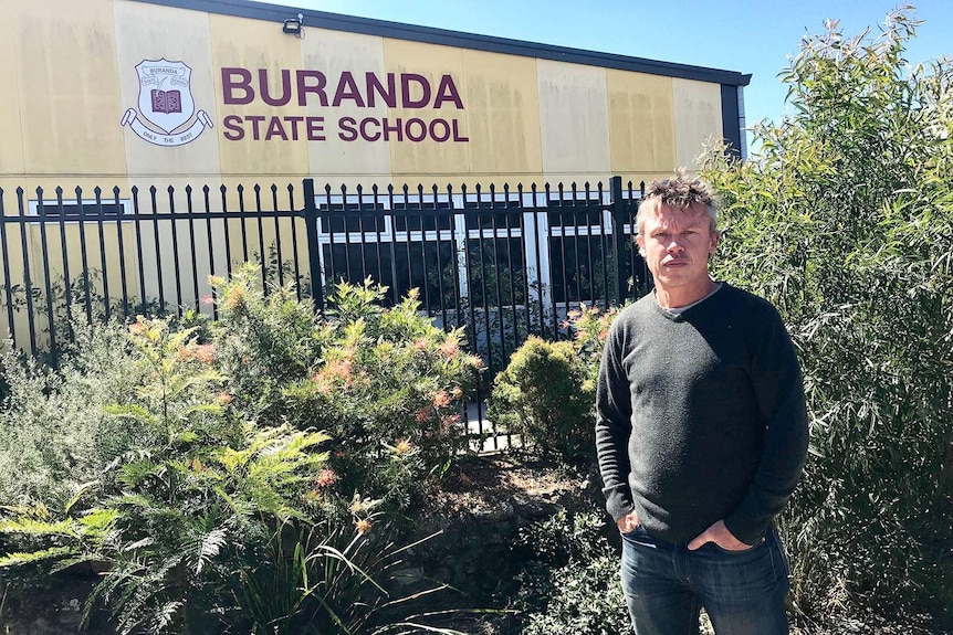 Craig Unthank stands outside one of the buildings at Buranda State School.