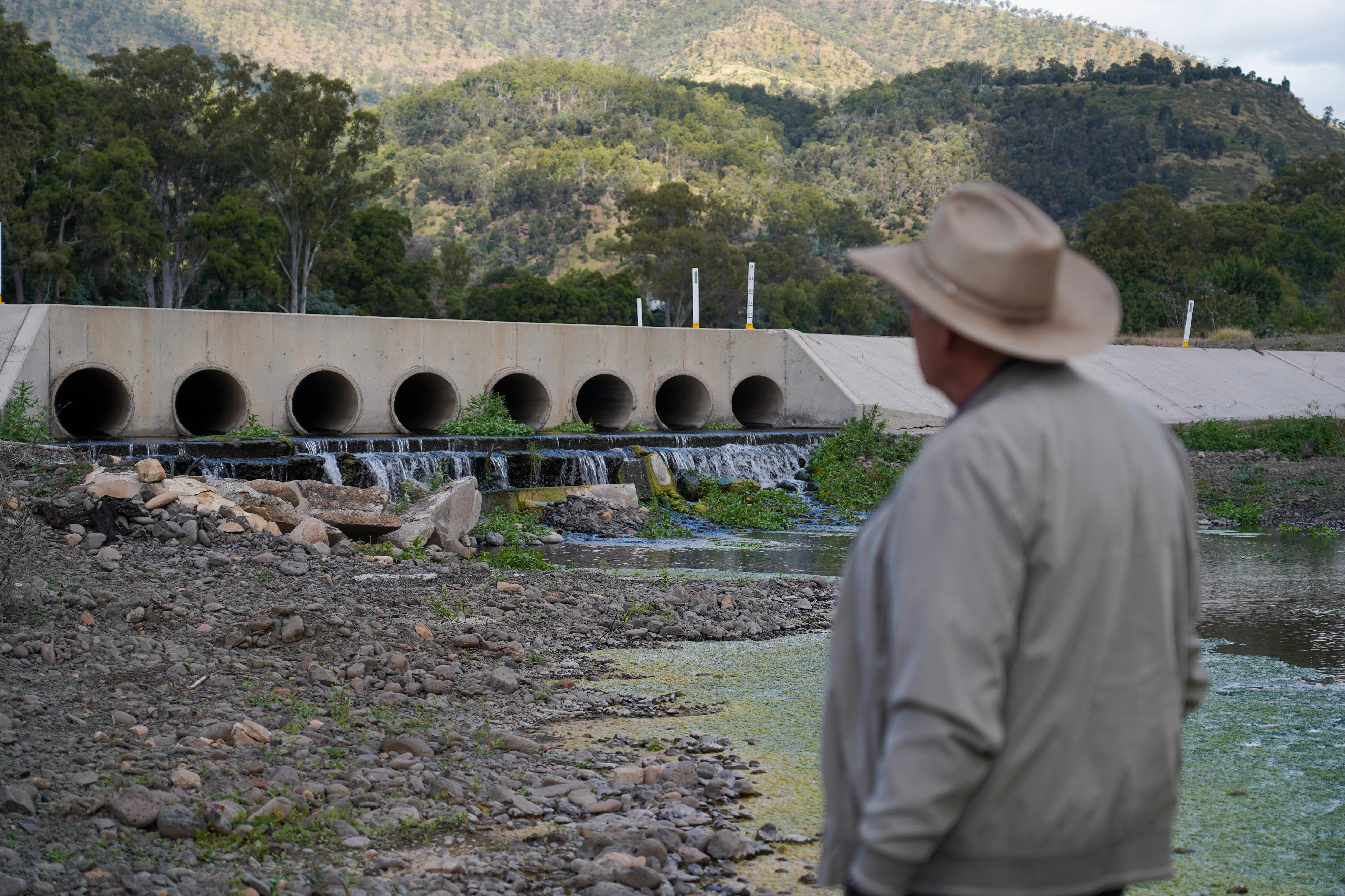 Man in hat standing in front of culverts