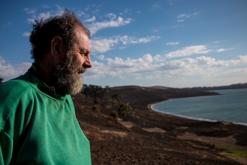 Dairy farmer Willie Hawker looks over the burnt out sides of Lake Bullen Merri.