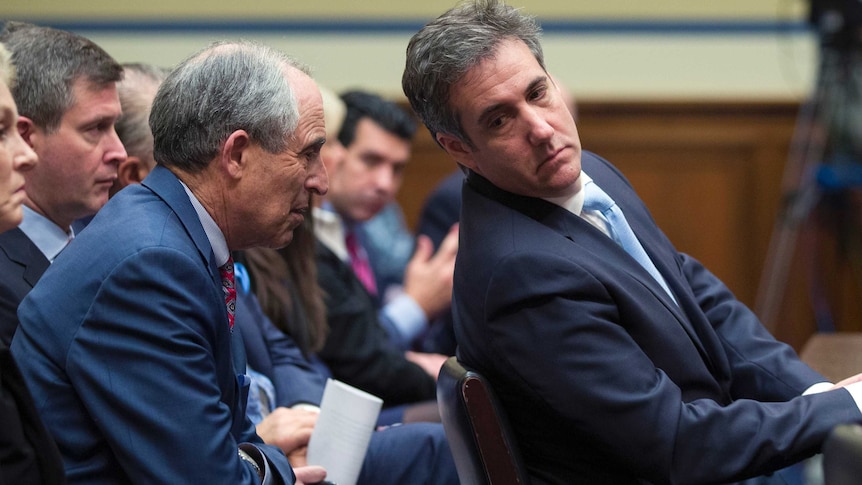 Michael Cohen talks to his lawyer during a House heading