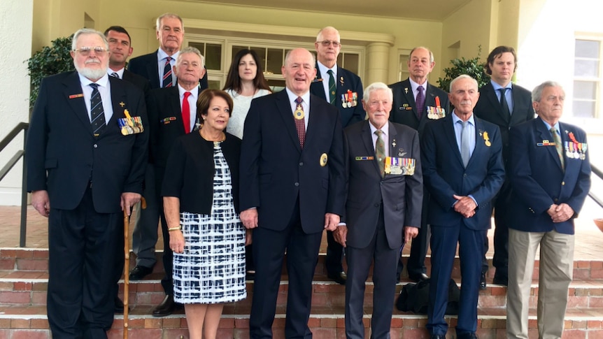 Australian soldiers who fought in the Vietnam War's Battle of Long Tan stand with Government General Sir Peter Cosgrove.