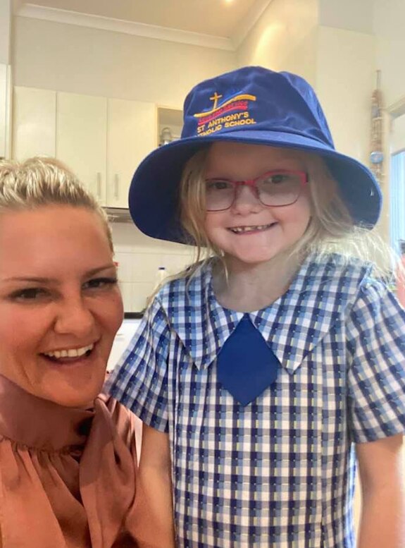 Harper in a school uniform next to her mother. 