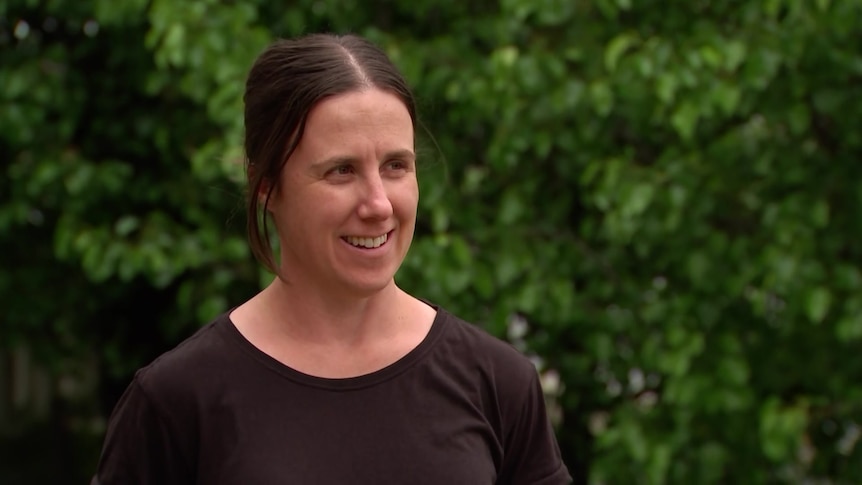 a woman with brown hair wearing a black top.