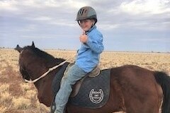 A boy sits on a horse
