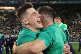 Two male Irish Test rugby union players embrace after defeating the All Blacks.