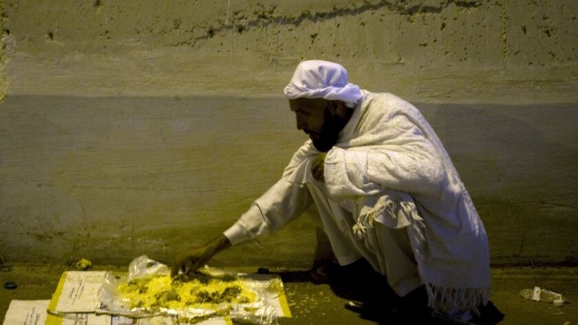 A Muslim pilgrim eats a free meal