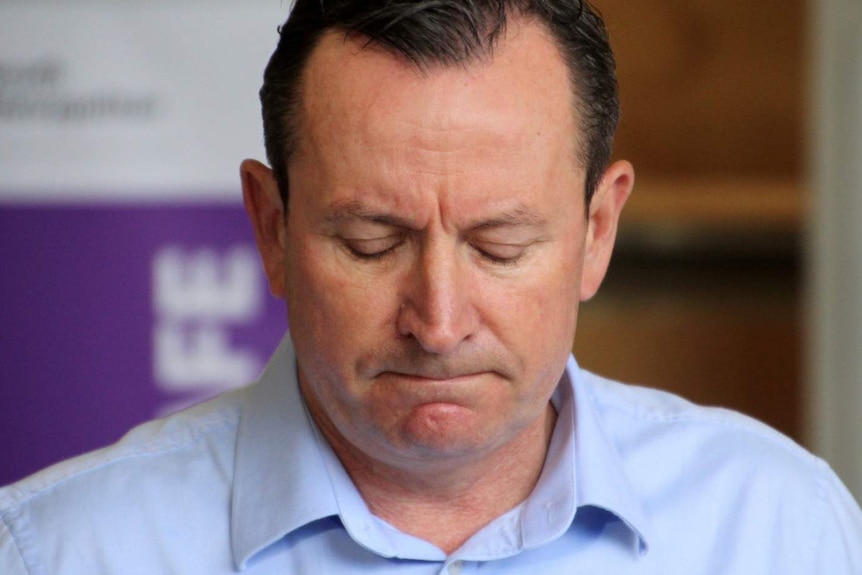 Mark McGowan looking down with his eyes closed during a press conference