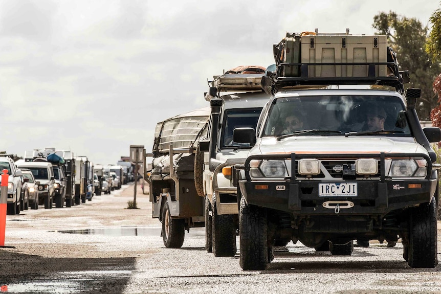 Row of cars and caravans queuing to cross the WA/SA border.