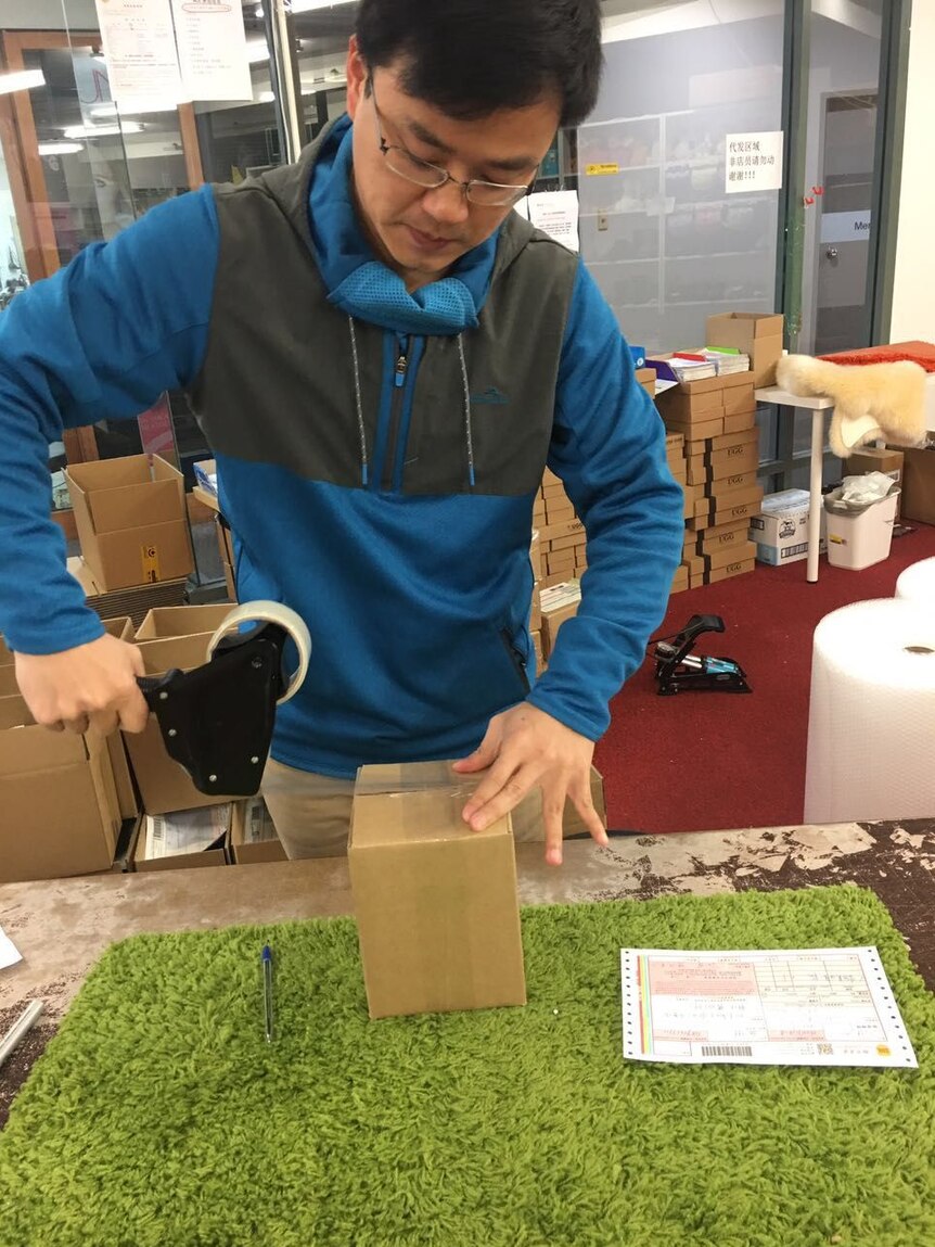 Ming Ouyang packs an order for a customer.
