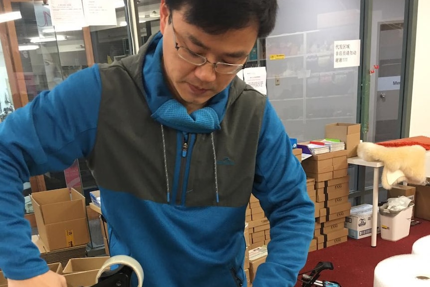 Ming Ouyang packing an order for a customer