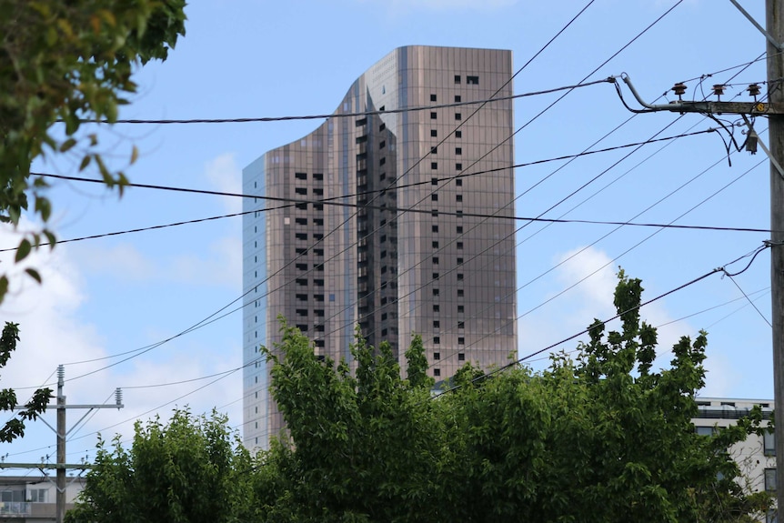 A view from the distance of a large silver skyscraper building.