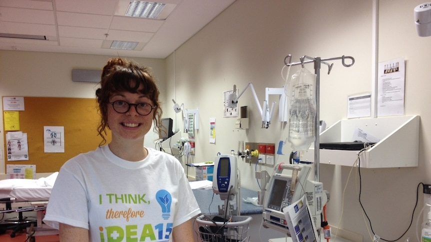 Medical student Alice McGushin stands in a hospital room.