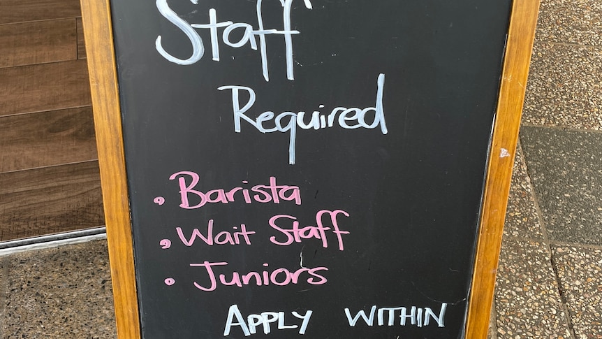 a blackboard outside a cafe advertising for staff 