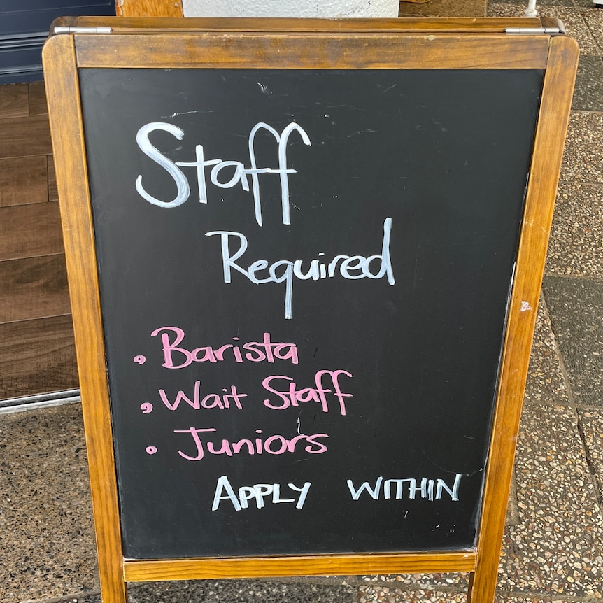 a board outside a cafe advertising staff 