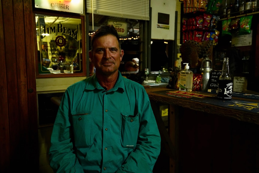 Man sitting in pub staring at camera