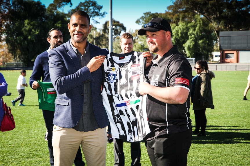 Michael O'Loughlin presented with a football jumper from Damian Bird from Castlemaine Football Netball Club.