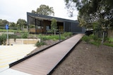 A walkway to a black modern building. 