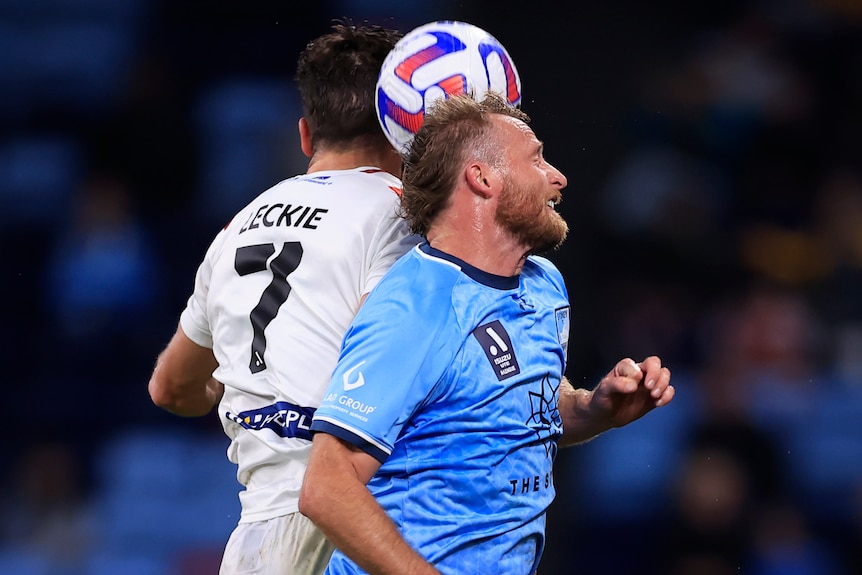 A Melbourne City A-League Men player is involved in an aerial challenge against a Sydney FC opponent.