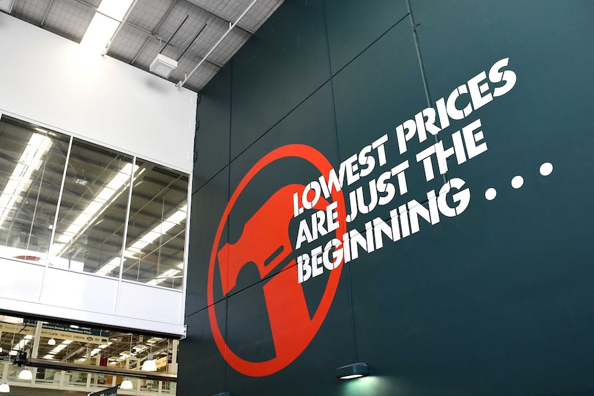 The Bunnings logo and slogan, "lowest prices are just the beginning" are painted on a dark green wall