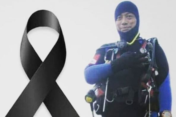A black ribbon superimposed next to a photograph of a man wearing diving equipment