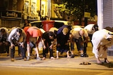 Several men bend at the hips in prayer in the street following an incident involving a van in Finsbury Park.