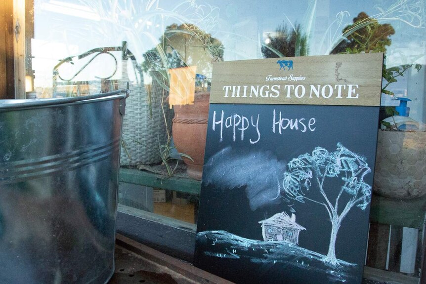 A chalkboard reads 'happy house' and shows a drawing of a farmhouse