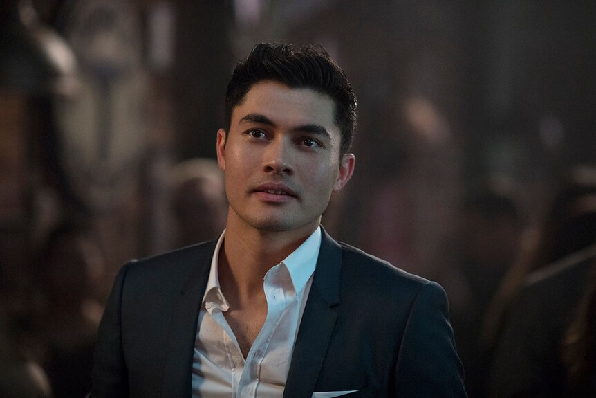 Close-up colour still of Henry Golding wearing a suit in 2018 film Crazy Rich Asians.