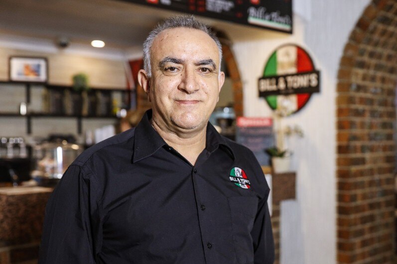 A man smiling in an Italian restaurant.