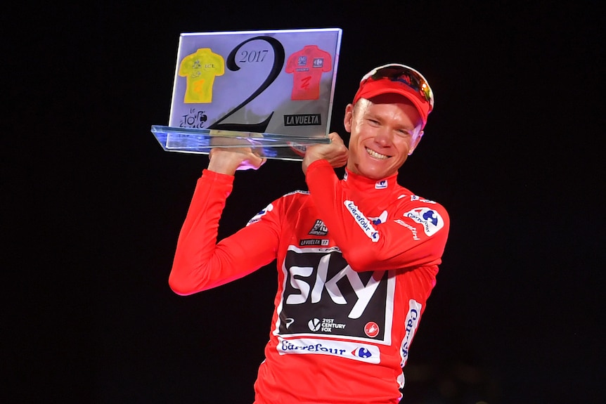 Chris Froome holds up a trophy
