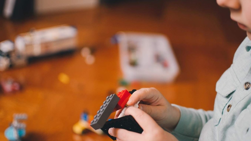 A young child plays with small blocks.