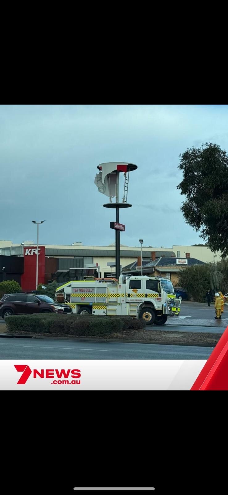 an emergency service vehicle at a KFC where it's signage has been destroyed by a storm