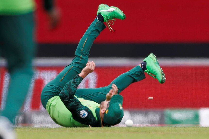 Faf du Plessis on his back with his legs in the air after dropping a catch against India at the Cricket World Cup.