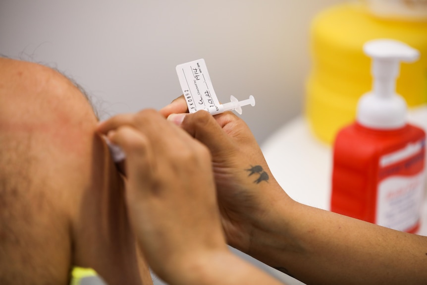 A vaccine going into a man's arm.