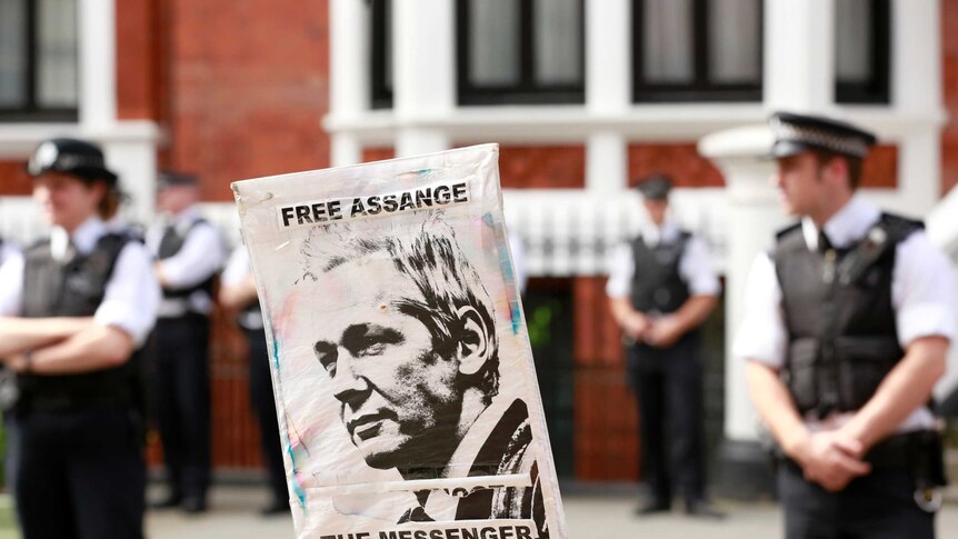 Police and protesters wait for Wikileaks founder Julian Assange