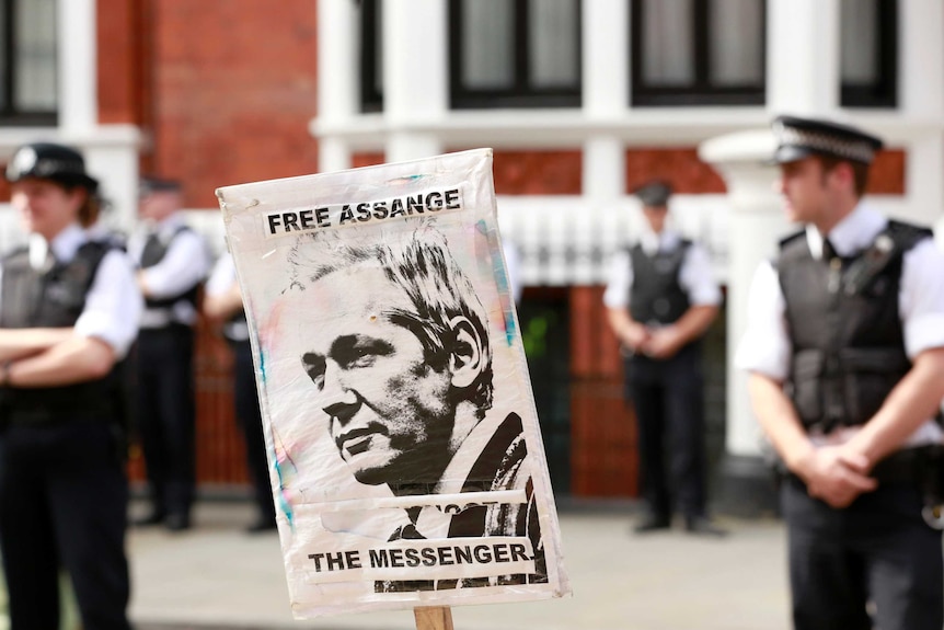 Police and protesters wait for Wikileaks founder Julian Assange
