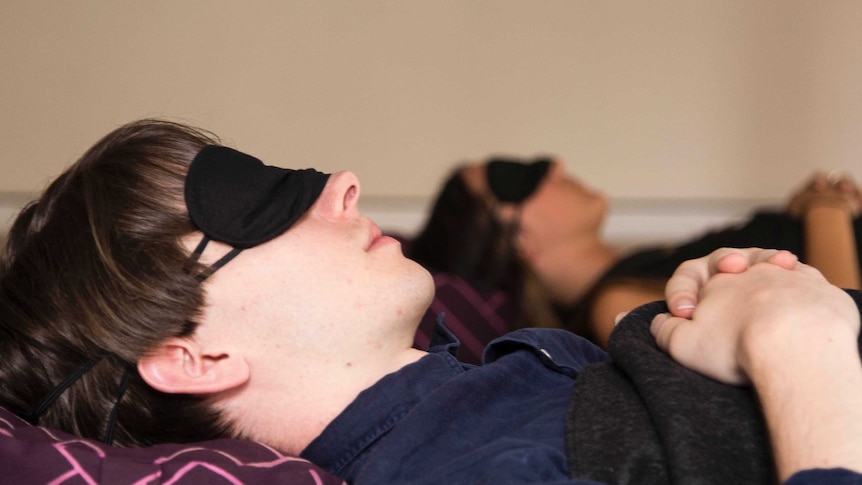 A man and a woman sleep in a guided nap class, Sydney, 2017