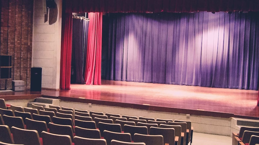 An empty stage and seats in a theatre.