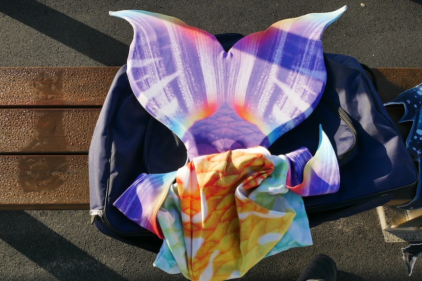 A colourful mermaid tail folded on top of a bag
