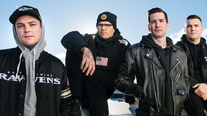 Group shot of The Amity Affliction; members dressed in black and grey jackets and hoodies
