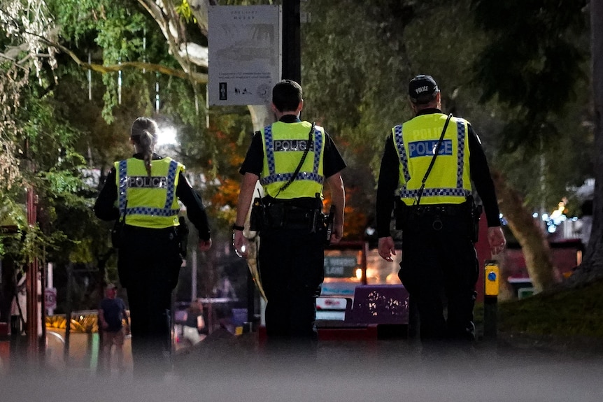 Police walk along a street at night in Alice Springs.