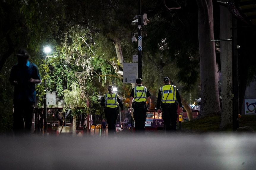 Police walk along a street at night in Alice Springs.