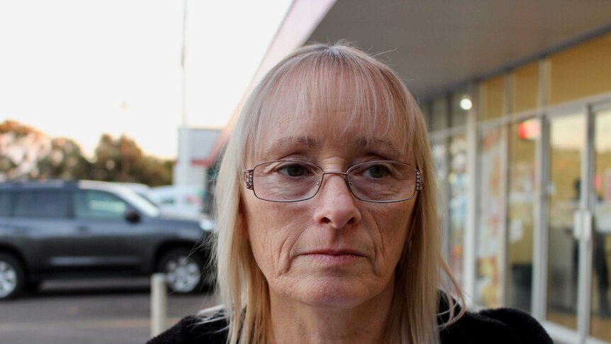 Karen Harrison looks sad standing outside her shop
