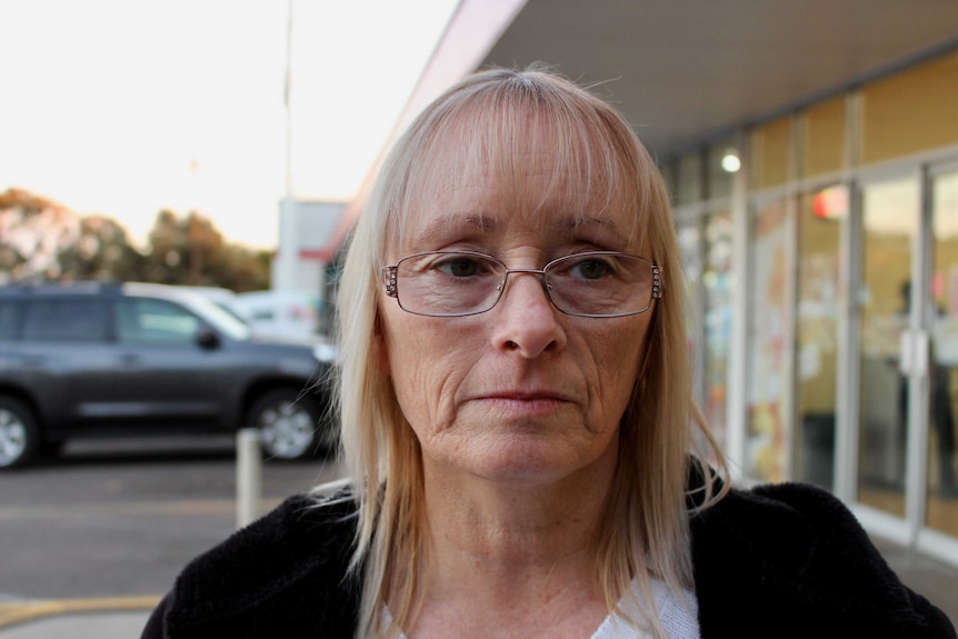 Karen Harrison looks sad standing outside her shop