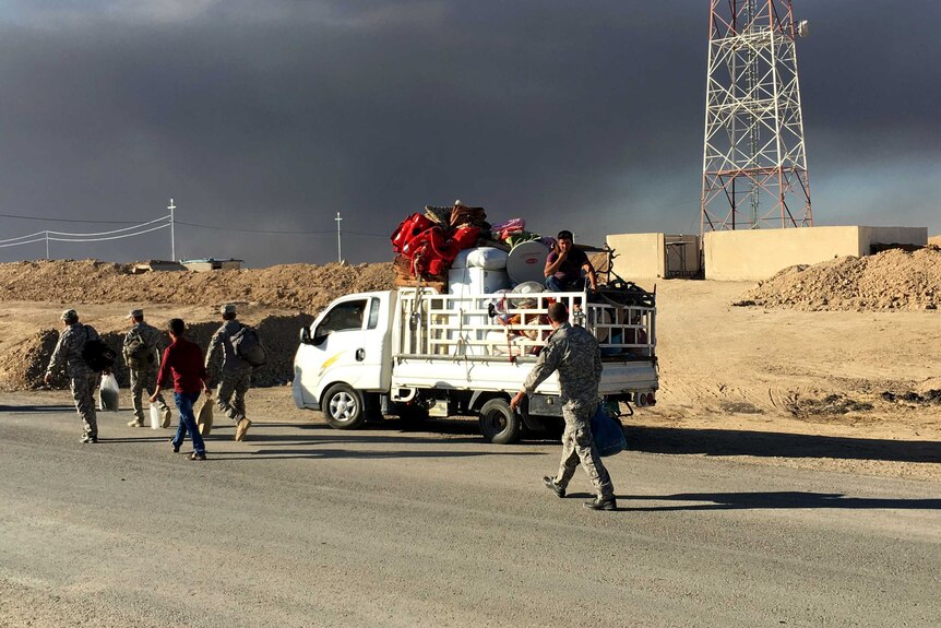 An Iraqi family with their belongings in a truck heads toward a checkpoint in Makhmour on their way back to their village.