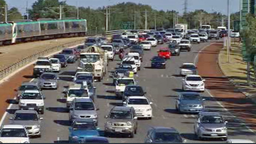 Mitchell freeway traffic heading south in bright daylight with train in background