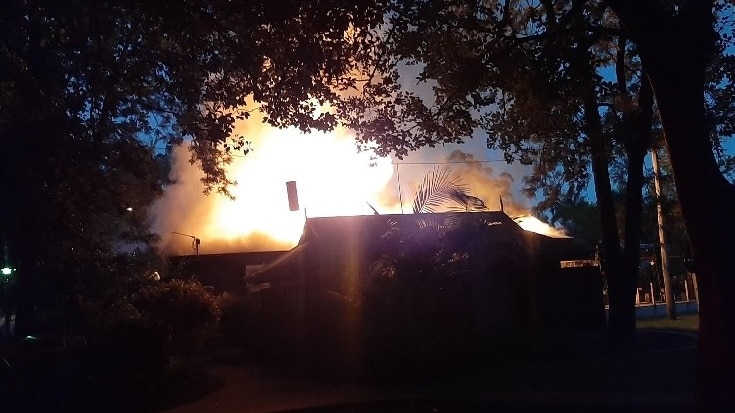 The bright glow of fire over a building in darkness