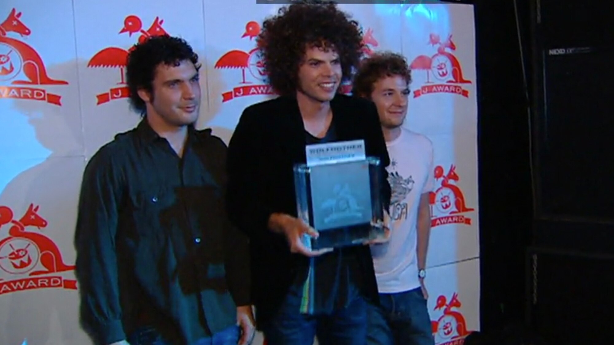 Three members of Wolfmother pose with trophy at the 2005 J Awards ceremony