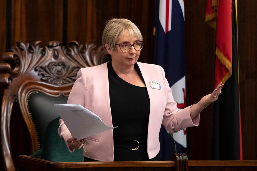 Michelle O'Byrne gestures in front of the speaker's chair in Tasmania's parliament.