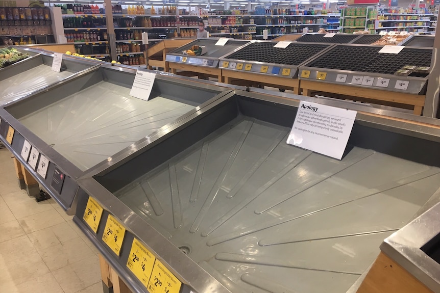 Empty fruit and vegetable shelves are seen at a Coles supermarket in Darwin 