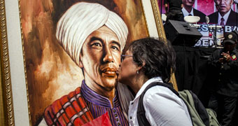 Woman kisses painting of Joko Widodo